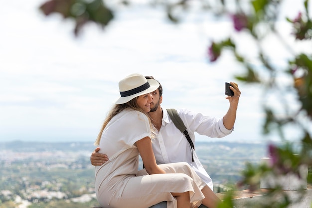 Couple taking selfies medium shot