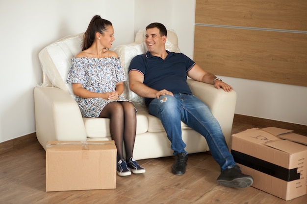 Couple talking to each other after unpacking the boxex in their new home