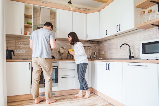 Couple talking at the kitchen man cooking breakfast