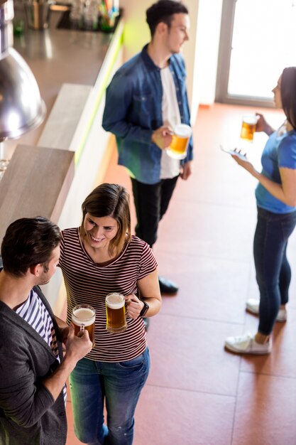 Coppie che parlano mentre bevendo birra nel bar
