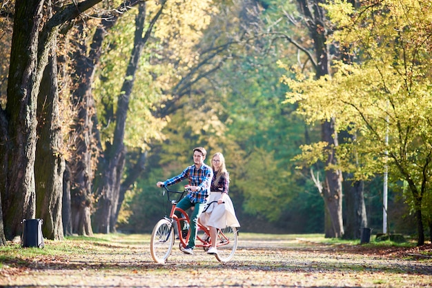 公園でタンデム自転車をカップルします。