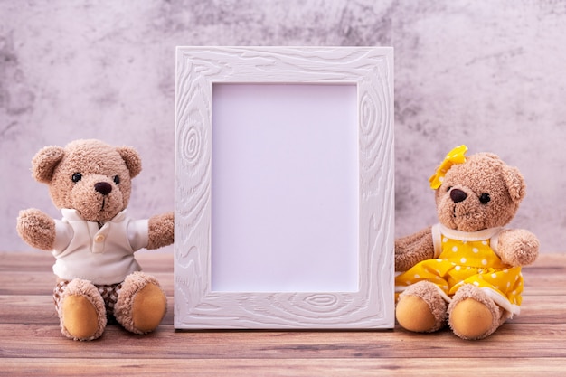 Couple teddy bear with Picture frame on table wooden.