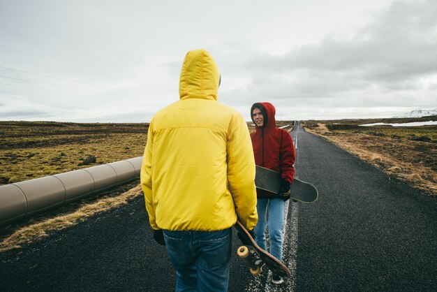 Couple of teenagers having fun skating and making downhill 