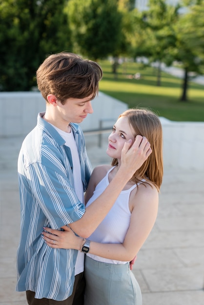 Couple of teenagers holding hands and hugging in the park The first love