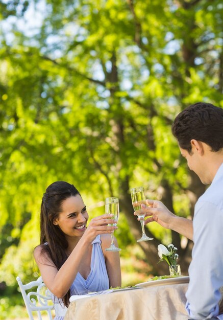 Couple toasting champagne flutes at an outdoor cafÃ©