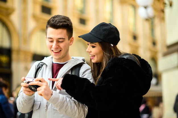 Couple of tourists looking at the pictures shot in their trip