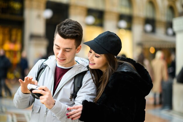 Couple of tourists looking at the pictures shot in their trip