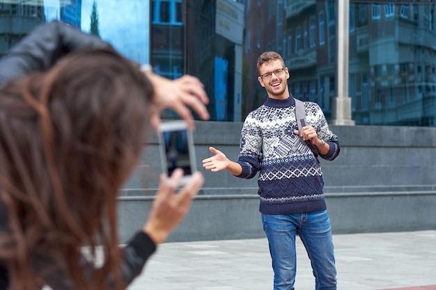 Couple of tourists making photo. Man posing for vacation photo in urban city tour.