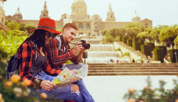 Couple of tourists study the map of ancient temple. Summer adventure of young man and woman