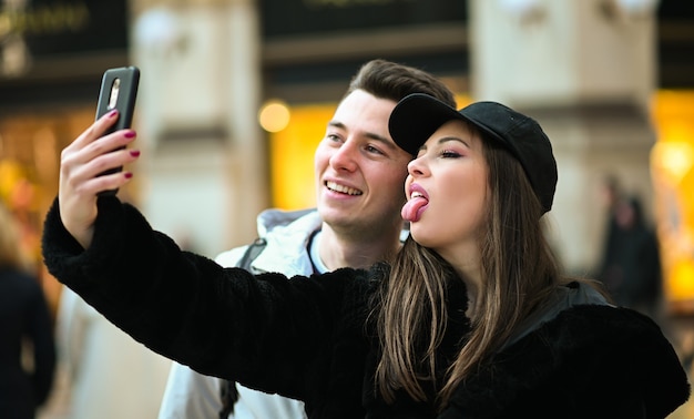 Couple of tourists taking funny selfies in Milan