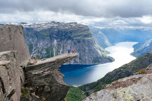 Photo couple of tourists on trolltunga in norway