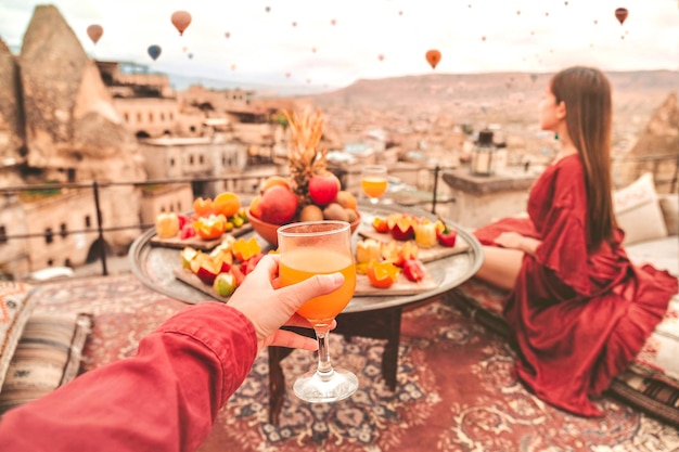 Couple Travel in Cappadocia Colorful hot air balloons flying over the valley sunrise time with special breakfast travel destination in Turkey