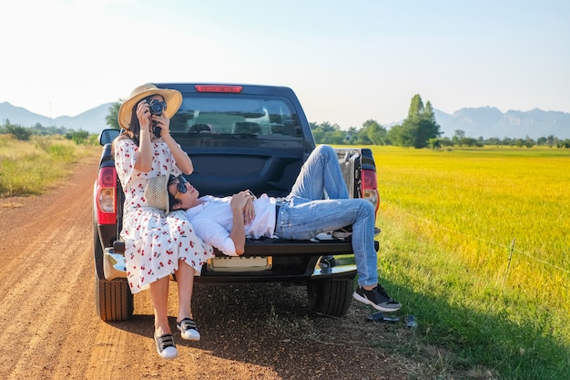 Couple traveler have a relax time during traveling beside the road.