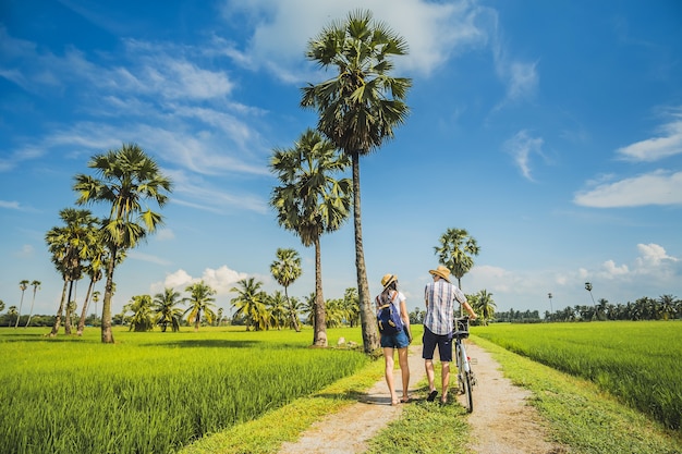 couple traveler taking bicycle and looking for view of rice field..