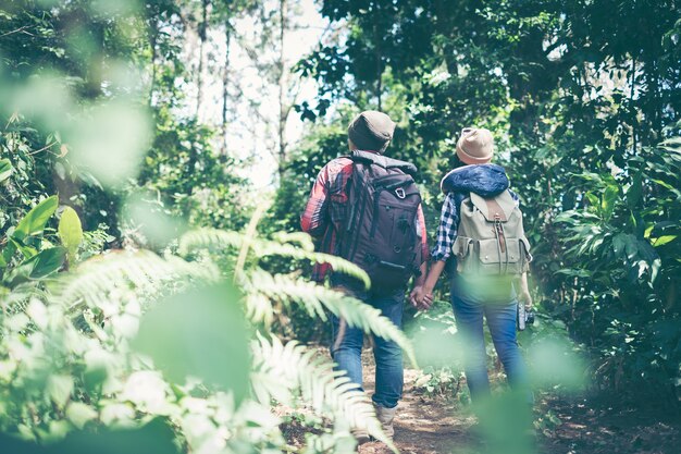 Couple travelers with backpacks relaxing in greens jungle