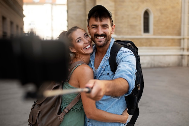 Photo couple traveling and taking selfie together in the city