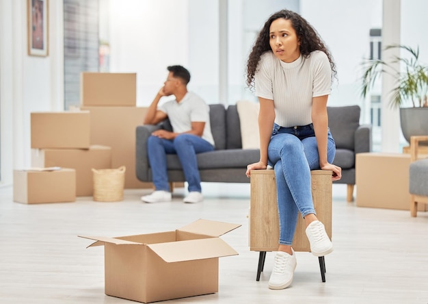 couple unhappy and woman worry with box for moving stress lost items and overwhelmed with change of home man sofa and upset with partner for furniture placement disagreement and miscommunication
