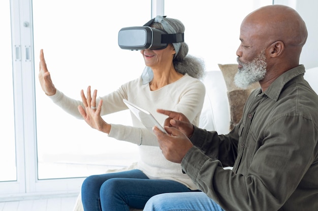 Photo couple using digital devices while sitting inside a room