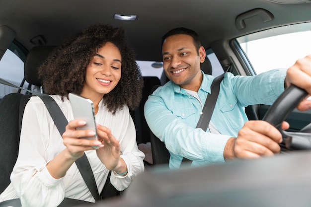 Couple using gps app on phone planning route driving car