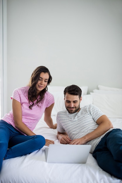 Couple using laptop in the bedroom at home