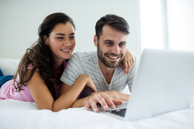 Couple using laptop in the bedroom at home