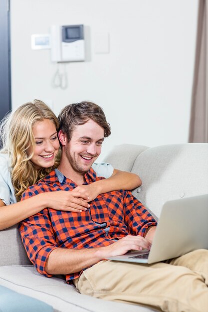 Couple using laptop on the couch in the living room