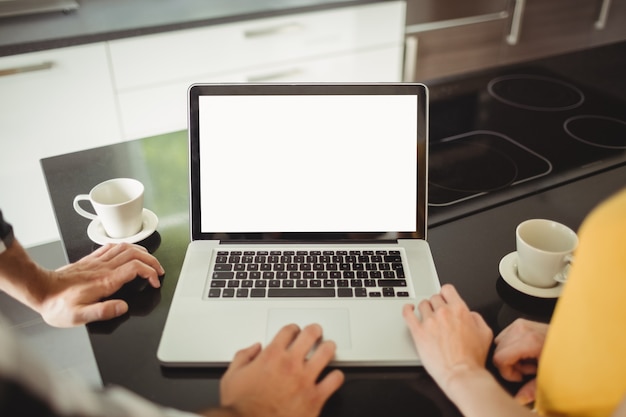 Couple using laptop in the kitchen