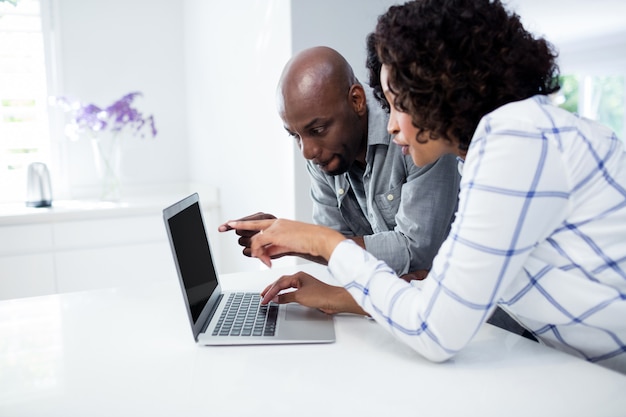 Couple using laptop in living room