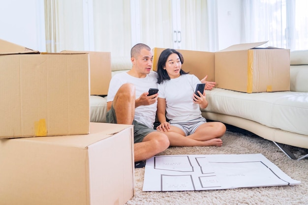 Couple using mobile phone to decorating new house