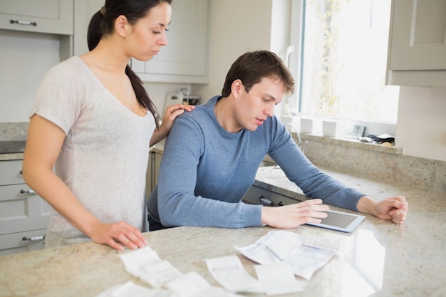 Couple using tablet pc to calculate finances