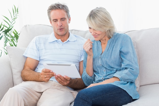 Couple using tablet together on the couch 