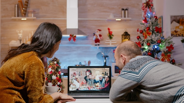 Couple using video call talking to family on christmas eve