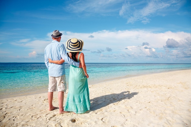 열 대 해변 몰디브에 산책 휴가에 커플. 남자와 여자는 해변에서 낭만적인 산책입니다.