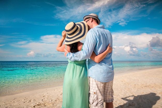 Couple on vacation walking on a tropical beach Maldives. Man and woman romantic walk on the beach.