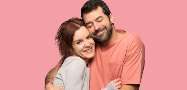 Couple in valentine day hugging over isolated pink background