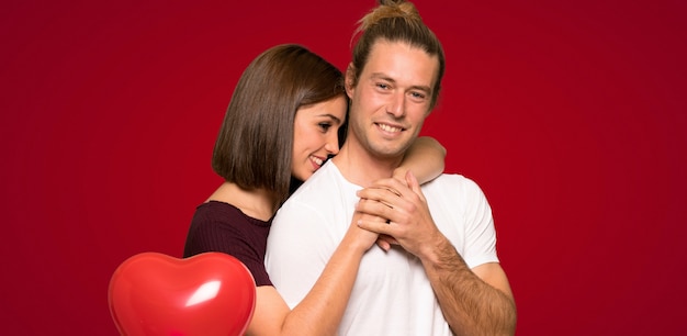 Couple in valentine day hugging over red background