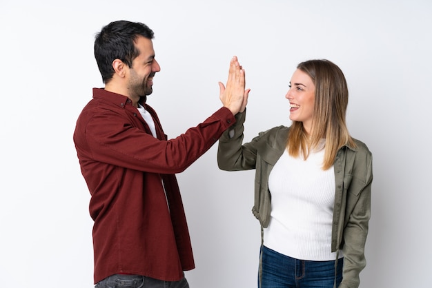 Couple in Valentine Day over isolated wall bumping hands