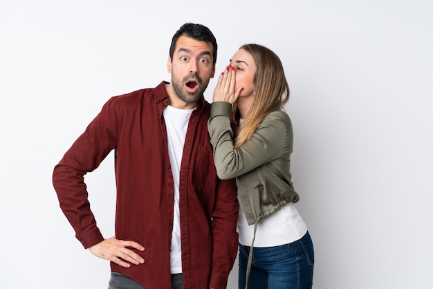 Couple in Valentine Day over isolated wall whispering something