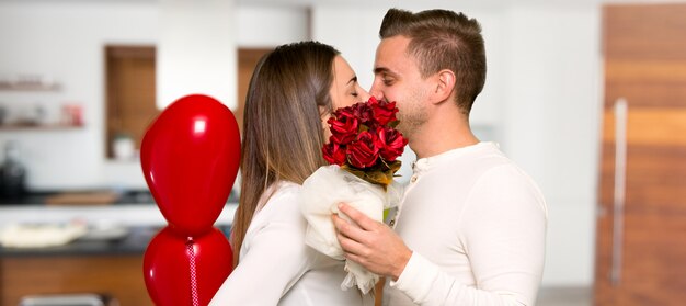 Couple in valentine day with flowers and balloons with heart shape in a house