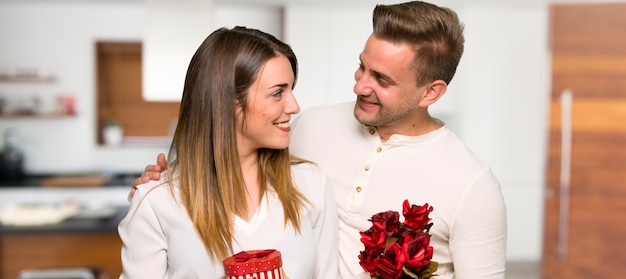 Пара в день Святого Валентина с цветами и подарками в доме