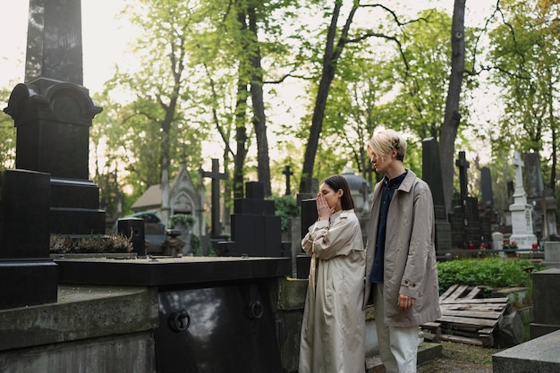 couple visiting a grave together at the cemetery