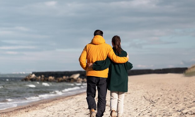 couple walking along autumn beach