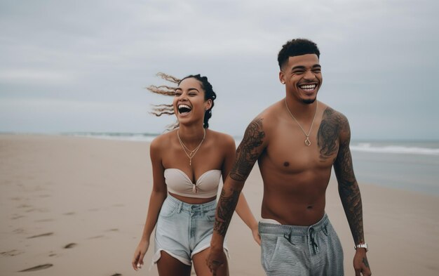 A couple walking on the beach, holding hands, smiling and laughing.