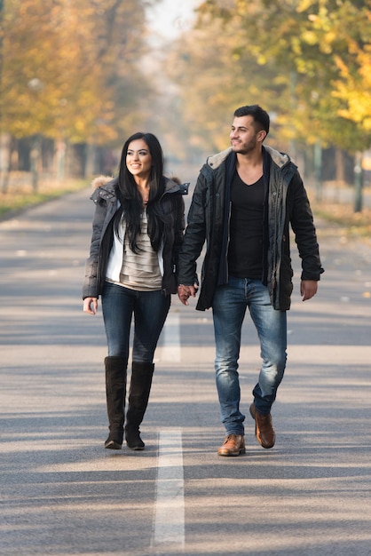 Couple Walking In Forest Through The Woods Outside During Autumn