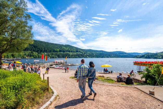 Photo couple walking at lakeshore against sky