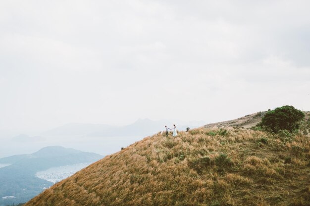 Photo couple walking on mountain peak against sky