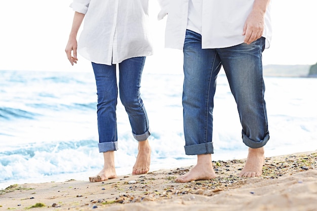 Photo couple walking at sea beach