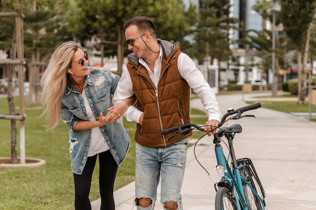 couple walking with a bike next to them