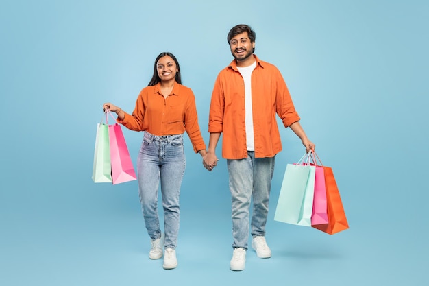 Couple walking with shopping bags looking happy