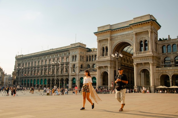 ミラノ美術館とヴィットリオ エマヌエーレ 2 世のガッレリアの前を歩くカップル